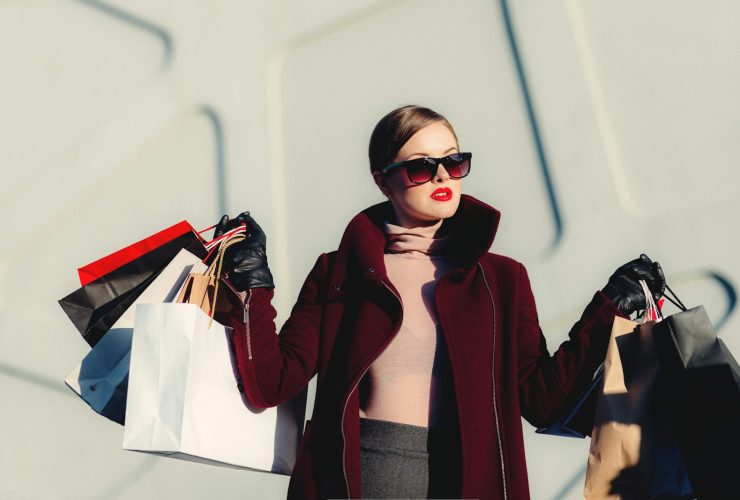 photo of woman holding white and black paper bags