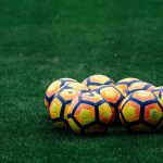 pile of yellow-orange-and-red Nike soccer balls