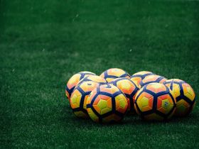 pile of yellow-orange-and-red Nike soccer balls