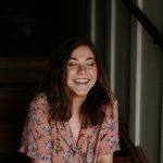 woman sitting on wooden stair smiling