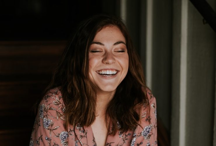 woman sitting on wooden stair smiling