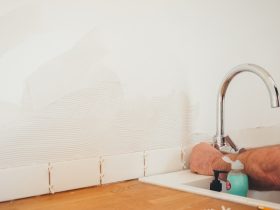 person holding gray curved faucet