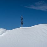 a street sign sitting on top of a snow covered hill